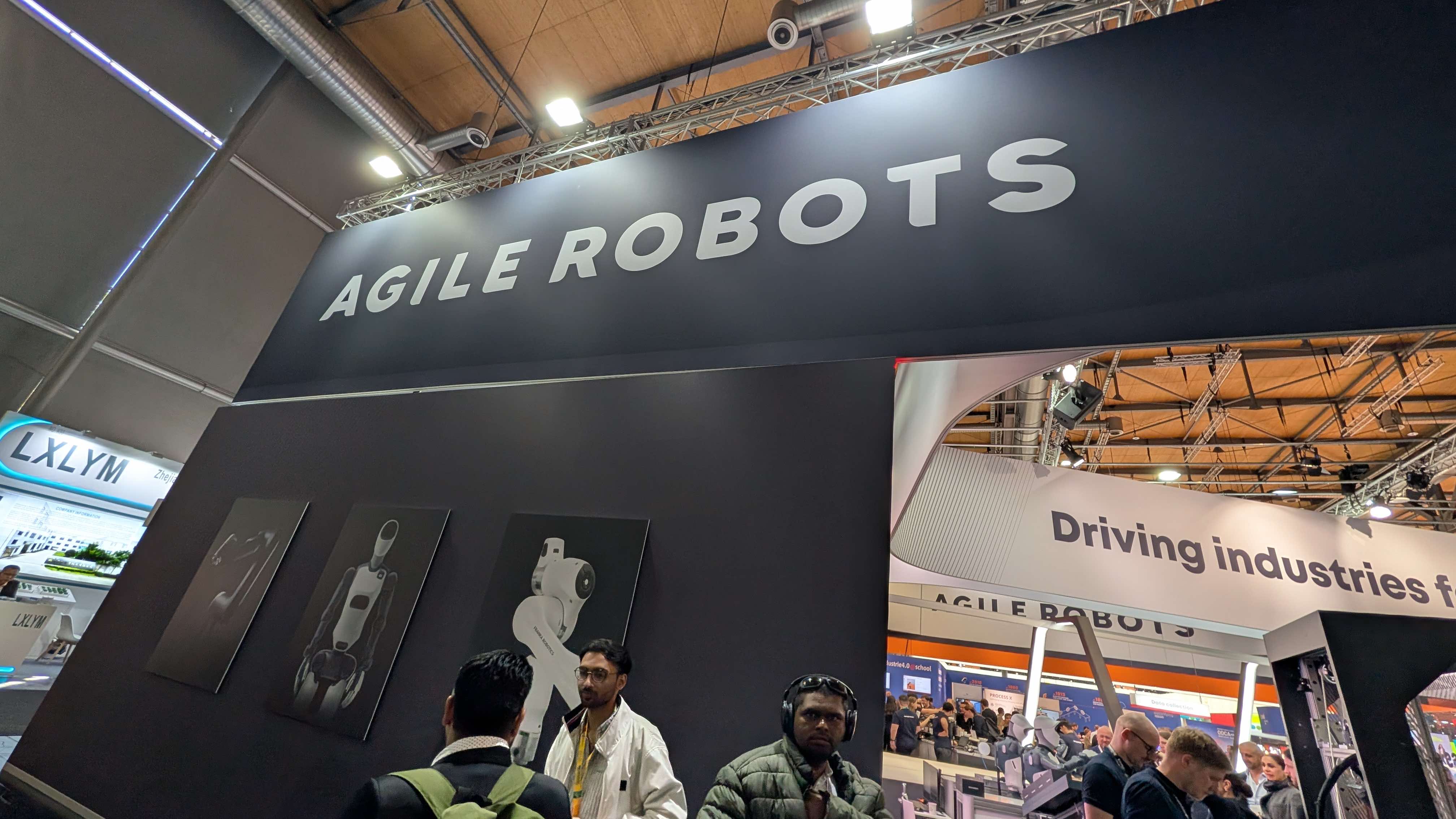 「AGILE ROBOTS」のサインと、ロボットハンド・ヒューマノイド・アームの製品パネル